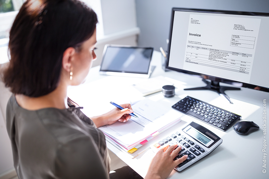 Une comptable règle les factures impayées.